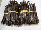 Bundles of vanilla beans tied with yellow string on a white background